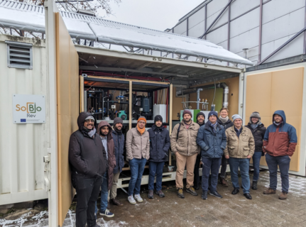 Gruppenfoto des Projekttreffens SolBio-Rev vor der Pilotanlage in Erlangen